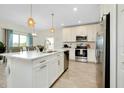 Modern kitchen with stainless steel appliances, white cabinets, and center island at 1920 Sunset Preserve Way, Port Charlotte, FL 33953