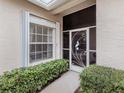 Front entry with a decorative screen door and lush green bushes at 1931 San Silvestro Dr, Venice, FL 34285