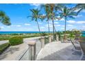 Ocean view patio with seating area, glass railing, and lush landscaping at 213 The Esplanade S, Venice, FL 34285