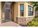 Front entry with a screened door and stone accents at 25064 Spartina Dr, Venice, FL 34293