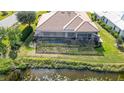 Home's back features a pool and screened patio overlooking the canal at 256 Royal Oak Way, Venice, FL 34292