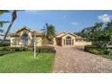 House exterior featuring a paver driveway and manicured lawn at 256 Royal Oak Way, Venice, FL 34292