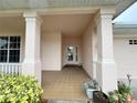 Covered front porch with tiled flooring and columns at 2890 Whispering Pine Ln, North Port, FL 34287