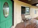 Inviting front porch with green door and seating area at 3187 Galiot Rd, Venice, FL 34293