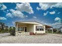 Single-wide mobile home with carport and landscaped yard at 3300 Blue Jay Ln, Englewood, FL 34224