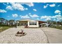 Single-wide mobile home with carport and landscaped yard at 3300 Blue Jay Ln, Englewood, FL 34224