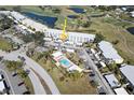 Aerial view of condo complex showcasing the pool, building location, and surrounding golf course at 408 Cerromar S Cir # 132, Venice, FL 34293