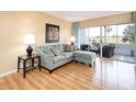 Living room with light walls, sectional sofa, and sliding glass doors leading to a patio at 408 Cerromar S Cir # 132, Venice, FL 34293
