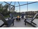 Relaxing screened patio with fire pit and lake view at 438 Grand Preserve Cv, Bradenton, FL 34212