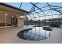 Inviting freeform pool and spa with screened enclosure and lake view at 438 Grand Preserve Cv, Bradenton, FL 34212