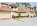 Tan two-story condo building with tile roofs, attached garages, and lush landscaping at 440 Palmetto Ct # 3, Venice, FL 34285