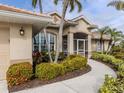 Well-maintained landscaping leads to a home with a screened porch at 5045 Whitestone Dr, Venice, FL 34293