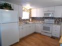 White kitchen with granite countertops, mosaic backsplash, and stainless steel appliances at 516 Ashwood Dr, Venice, FL 34285
