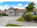 Tan two-car garage villa with landscaped yard at 640 Back Nine Dr, Venice, FL 34285