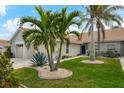 Tan villa with two-car garage and lush landscaping at 640 Back Nine Dr, Venice, FL 34285