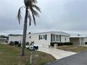 Single-wide manufactured home with mailbox and palm tree at 863 Baveno Dr, Venice, FL 34285