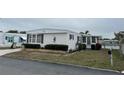 Single-wide manufactured home with water view and landscaping at 863 Baveno Dr, Venice, FL 34285