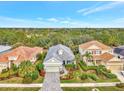 House with gray roof and light green walls, paver driveway and landscaping at 12386 Sagewood Dr, Venice, FL 34293