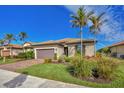 Single-story house with a brown garage door and lush landscaping at 13836 Karina St, Venice, FL 34293