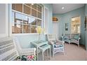 Relaxing front porch with white wicker furniture, perfect for enjoying the Florida sunshine at 1630 Monarch Dr, Venice, FL 34293