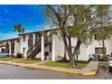 Front view of condo building, showing landscaping and parking at 1640 Stickney Point Rd # 202, Sarasota, FL 34231