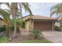 House exterior with a two-car garage and palm trees at 19155 Mangieri St, Venice, FL 34293