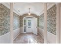 Elegant entryway with tiled floors and decorative wallpaper at 20 Saint Croix Way, Englewood, FL 34223
