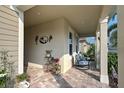 Covered porch with rocking chairs, potted plants, and paver floor at 20389 Minuet Pl, Venice, FL 34293