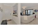 Bright entryway with a bench and view into the living room at 23210 Banbury Way # 101, Venice, FL 34293