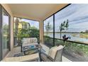Relaxing screened lanai overlooking a lake with comfortable seating at 23210 Banbury Way # 101, Venice, FL 34293