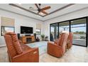 Relaxing living room with leather furniture and sliding doors to pool area at 23402 Copperleaf Dr, Venice, FL 34293