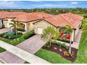 New construction home with tile roof and lush landscaping at 24165 Spartina Dr, Venice, FL 34293
