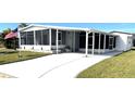 Front view of a mobile home with a paved driveway and screened porch at 28 Castaway Ct, North Port, FL 34287
