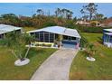 Mobile home with driveway and surrounding landscape at 3022 Audubon Ave, Englewood, FL 34224