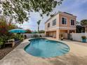 Inviting kidney-shaped pool with patio furniture and umbrellas in a fenced backyard at 321 Pedro St, Venice, FL 34285