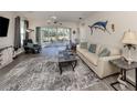 Comfortable living room with neutral colors, ceiling fan, screened lanai access, and modern furnishings at 335 Sunset Lake Blvd, Venice, FL 34292