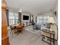 Open-concept living room and dining area with neutral decor, ceiling fans, and screened lanai access at 335 Sunset Lake Blvd, Venice, FL 34292