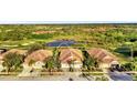 Aerial view showcasing a villa near golf course and pond at 4259 Whispering Oaks Dr, North Port, FL 34287