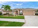 Tan house with tile roof, landscaping, and a circular driveway at 430 Marsh Creek Rd, Venice, FL 34292