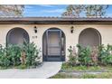 Front entrance with arched entryway and screen door at 519 Rubens Dr # 519, Nokomis, FL 34275