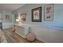 Light hallway with wood-look floors and unique wall art at 609 Constance Rd, Venice, FL 34293