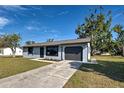 Newly renovated home with gray exterior, landscaping, and a two-car garage at 6670 Harmony Rd, North Port, FL 34287