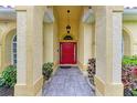 Inviting entryway with a red door and arched columns at 7023 Chickasaw Bayou Rd, Bradenton, FL 34203