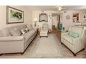 Living room with light beige couch and striped armchairs at 806 Capri Isles Blvd # 109, Venice, FL 34292
