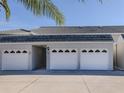 Three-car garage with attached entryway to condo building at 936 Capri Isles Blvd # 102, Venice, FL 34292