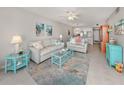 Bright living room with light beige sofas, teal accents, and coastal decor at 936 Capri Isles Blvd # 102, Venice, FL 34292