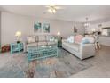 Bright living room with light beige sofas, teal accents, and coastal decor at 936 Capri Isles Blvd # 102, Venice, FL 34292