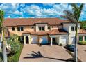 An aerial view showcases a well maintained two-story townhome with tiled roof and brick paver driveways at 10059 Crooked Creek Dr # 202, Venice, FL 34293