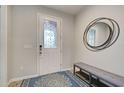 Bright foyer featuring a decorative front door, stylish round mirror, and bench with shoe rack at 11842 Sistine Ln, Venice, FL 34293