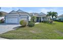 Two-story home with gray siding, three-car garage, and manicured lawn at 12353 Auburndale Ct, Venice, FL 34293